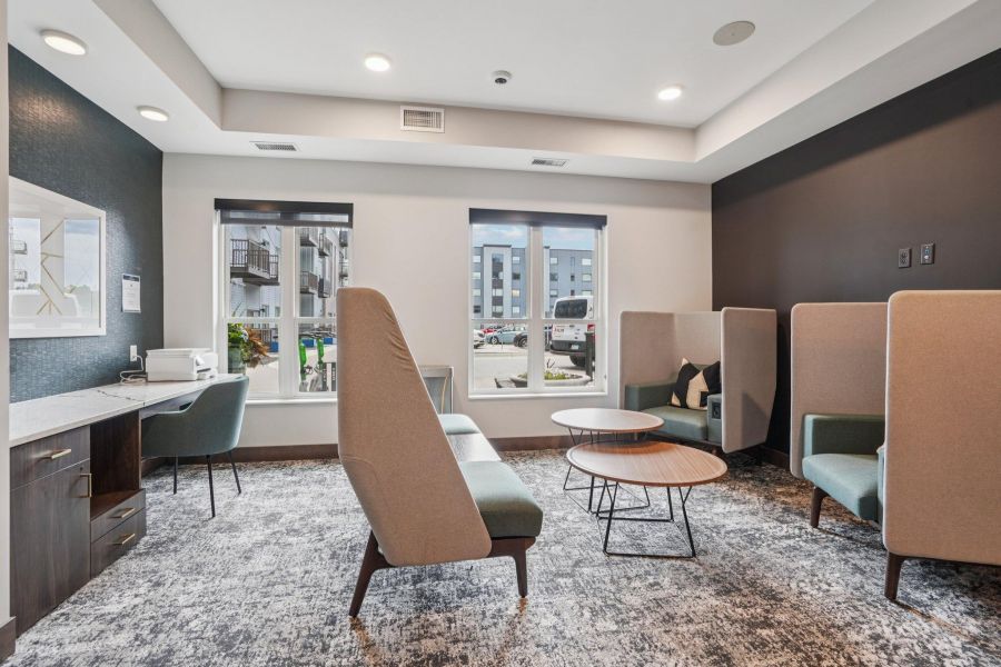 The Scenic modern lounge area with couches, round tables, armchairs, and large windows letting in natural light.